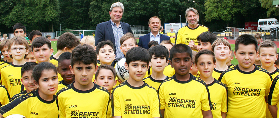 Bildzeile: „Reifen Stiebling“-Geschäftsführer Christian Stiebling mit Schirmherr Olaf Thon und Fußball-Camp-Trainer Lothar Woelk (hintere Reihe von links).